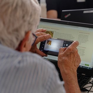 Eine Person fotografiert den Bildschirm eines Laptops