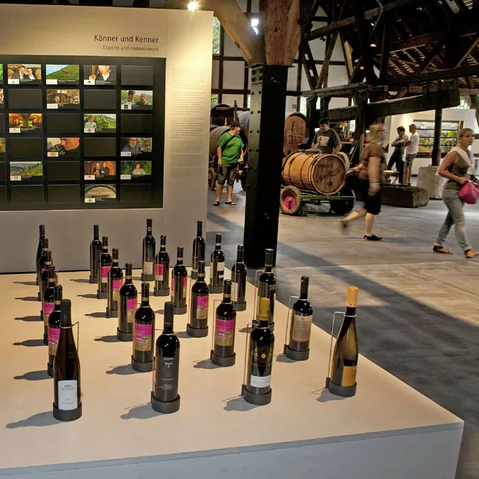 Blick in die Ausstellung: Im Vordergrund Weinflaschen, im Hintergrund Geräte.