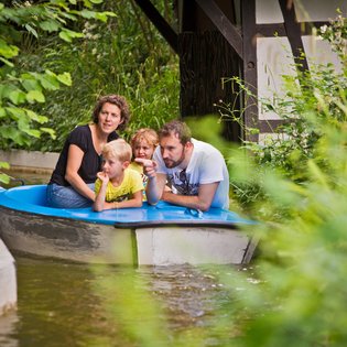 Eine Familie fährt in einem Boot im Märchengarten