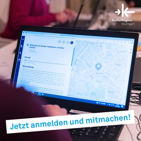 An der rechten, nur undeutlich erkennbaren Schulter einer Person von hinten vorbei ist der Bildschirm eines Laptops zu sehen an dem die Person scheinbar gerade arbeitet.Auf dem Bildschirm ist ein Eintrag zu Jewish Places mit einem Beschreibungstext und der Verortung des Eintrags in einer Karte zu erkennen.